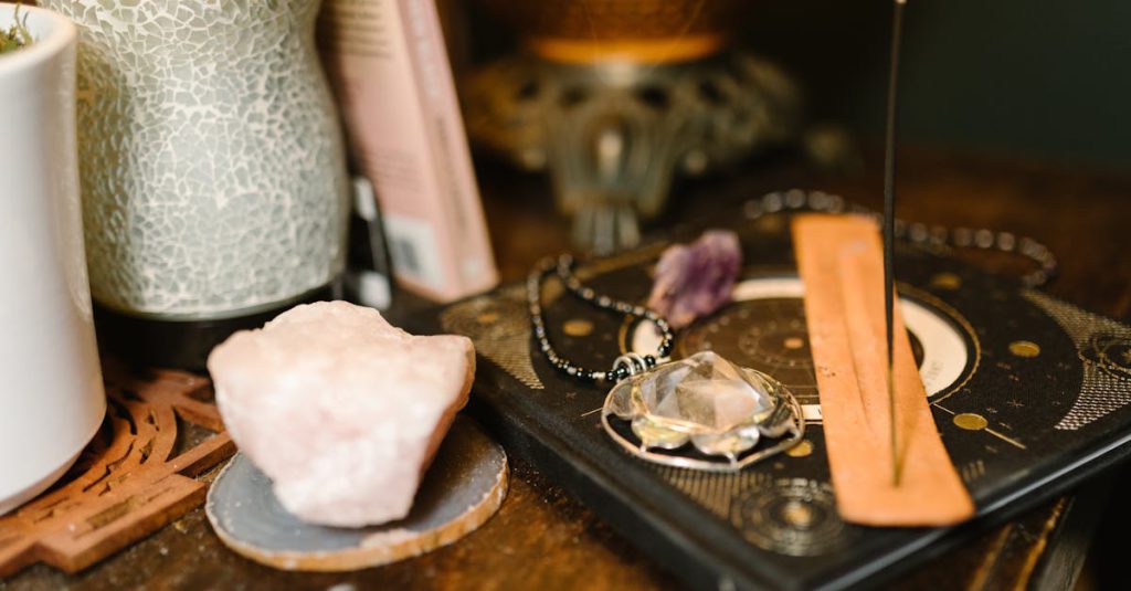 Warm-toned composition featuring incense, rose quartz, and mystical elements on a wooden surface.
